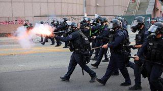 Riot police and protesters clash after LA immigration raids – BBC